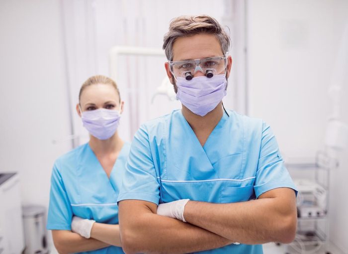 Portrait of dentist standing with arms crossed at dental clinic